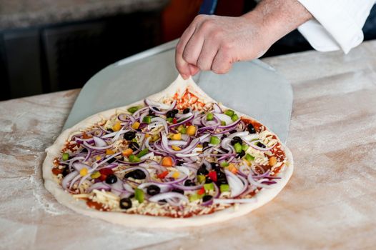 Cropped image of male chef handling pizza