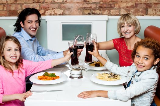 Cheerful family of four celebrating, Cheers!