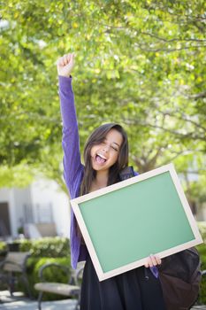 Portrait of An Attractive Excited Mixed Race Female Student Holding Blank Chalkboard and Carrying Backpack on School Campus.