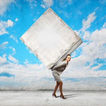 Image of businesswoman carrying big white cube on her back. Place for text