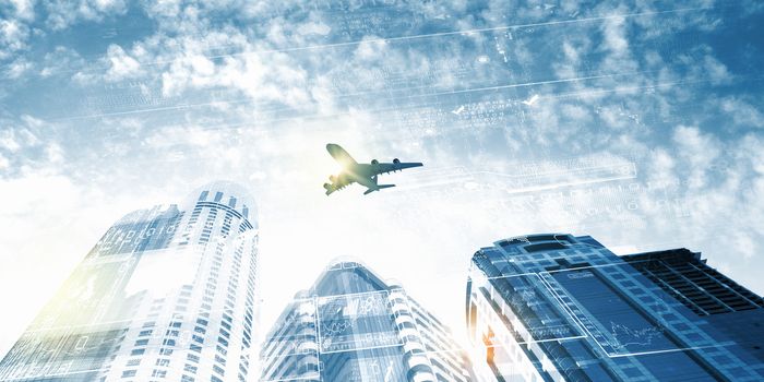 Plane flying above skyscrapers. Business travel concept