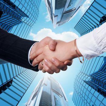 Close up image of hand shake against skyscrapers