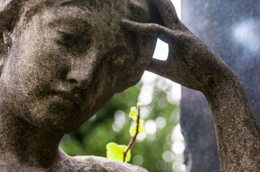 detail of a mourning sculpture on a cemetery