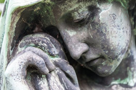 detail of a mourning sculpture on a cemetery