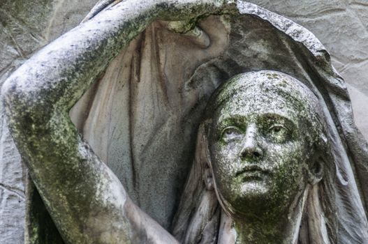 detail of a mourning sculpture on a cemetery