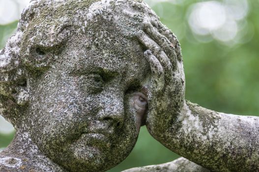 detail of a mourning sculpture on a cemetery