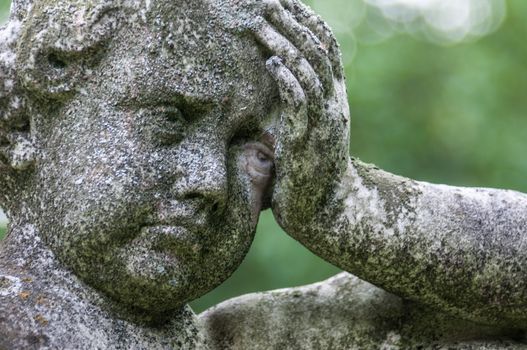 detail of a mourning sculpture on a cemetery