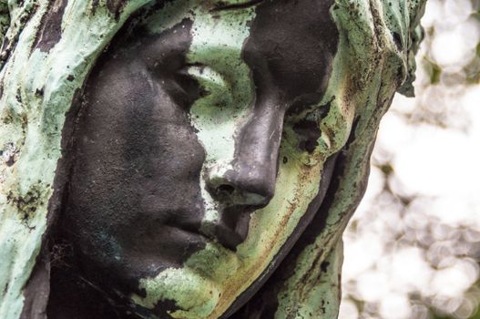 detail of a mourning sculpture on a cemetery