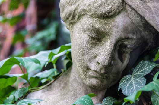 detail of a mourning sculpture on a cemetery