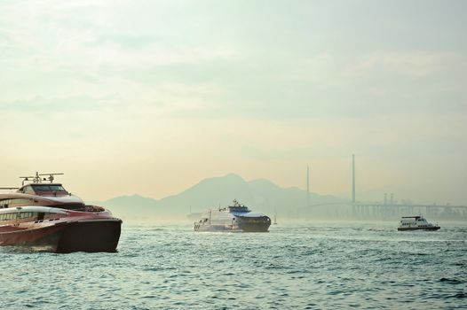 Macao to Hong Kong ferry boats in Hong Kong harbor. Tsing-Ma Bridge on the background