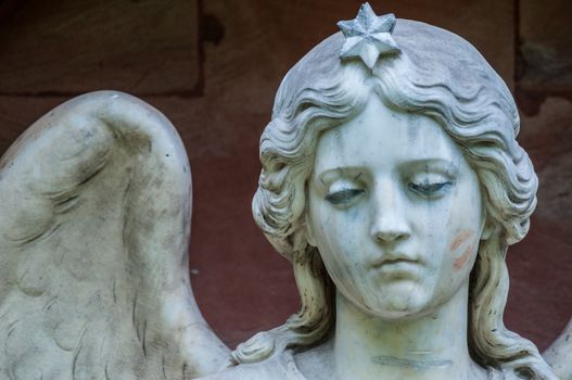 detail of a mourning sculpture on a cemetery