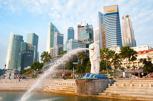 Singapore, Republic of Singapore - March 08, 2013: The Merlion fountain spouts water in front of the Singapore skyline in Singapore. Merlion is a creature with a lion head, often seen as a symbol of Singapore