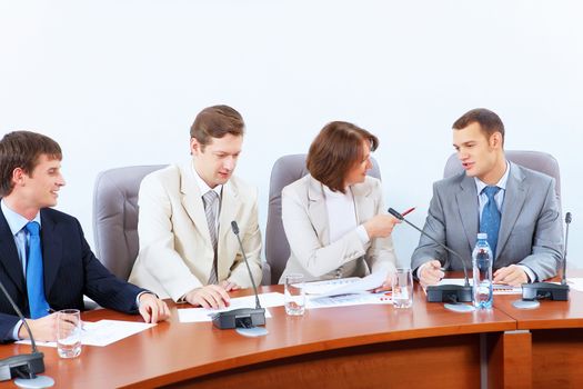 Image of four businesspeople discussing at meeting