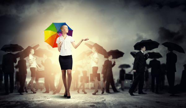 Image of pretty businesswoman with umbrella walking in crowd of people