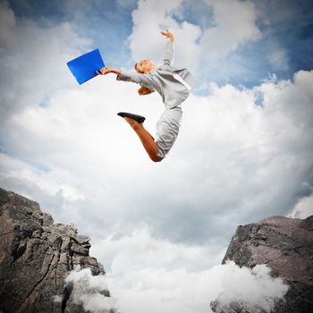 Image of young businesswoman jumping over gap