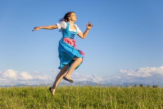 A woman in bavarian traditional dirndl in the nature