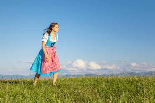 A woman in bavarian traditional dirndl in the nature