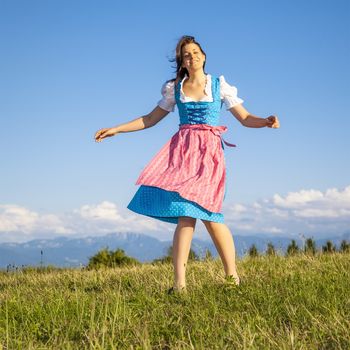 A woman in bavarian traditional dirndl in the nature