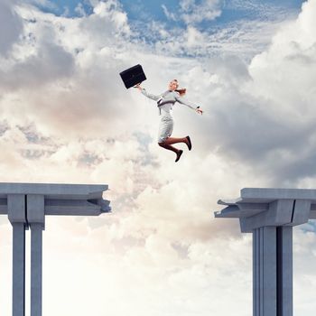 Young woman jumping over a gap in the bridge as a symbol of risk