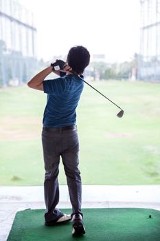 Young male golfer practicing his drive