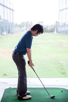 Young male golfer practicing his drive