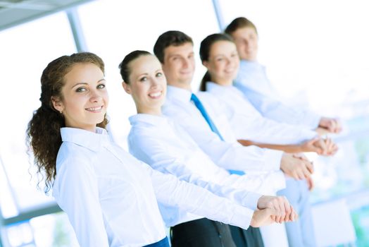 young business people holding hands, standing in a row, the concept of teamwork