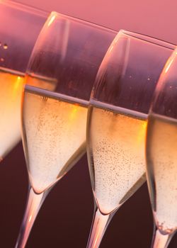 Close up glasses of champagne with sunset background