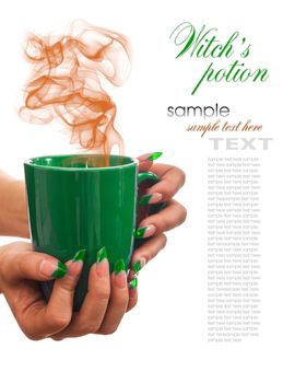 Witch's potion in a green cup in the hands of the sorceress