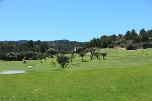 Beautiful lush green golf course with carefully tended and manicured greens