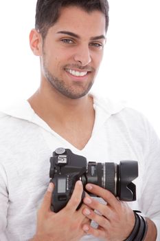 Smiling good looking man with unshaven stubble standing with a digital camera in his hands isolated on white