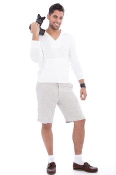 Smiling successful male photographer standing in a pair of shorts holding his dslr in his hand, full length portrait on white