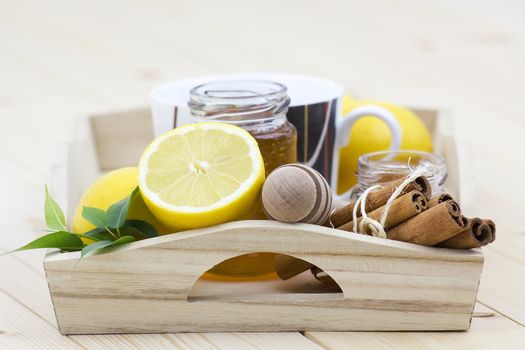 cup of tea, honey, cinnamon sticks and fresh lemons