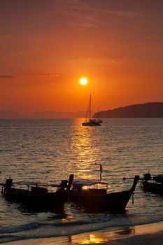 Longtail boats against a sunset. Ao-Nang, Thailand.