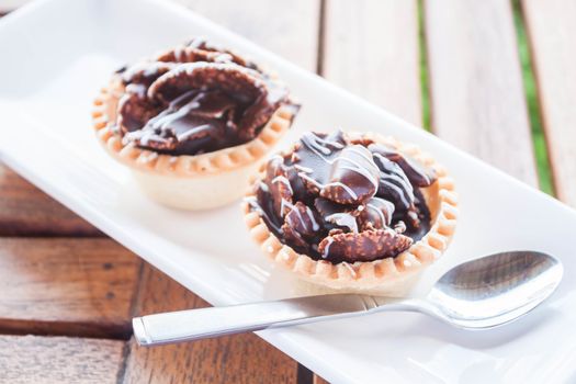 Crispy chocolate tarts on white plate, stock photo