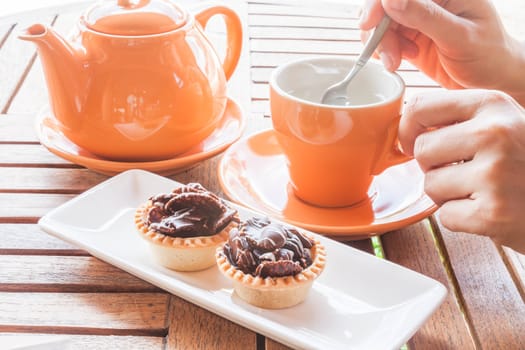 Hot cup of white tea and crispy chocolate tarts, stock photo