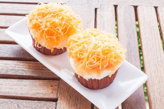 Gold egg yolk thread cakes on white dish, stock photo