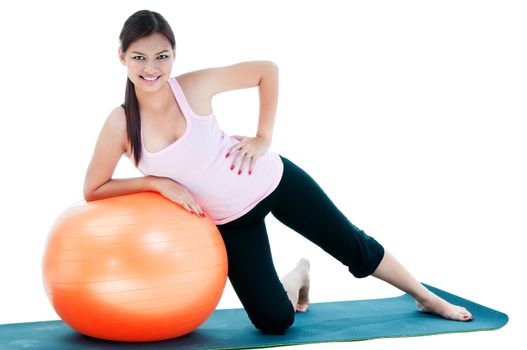 Portrait of pretty young woman doing exercise on balance ball.