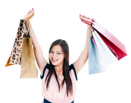 Portrait of an excited young woman carrying shopping bags over white background