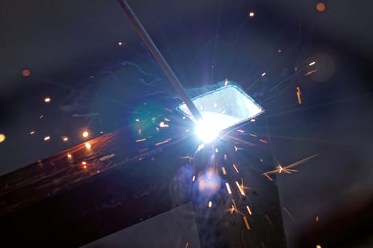 Iron welding with bright light and smoke at manufacturing