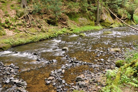 A small river flows through a wild landscape with rocks