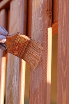 planks fence dyeing with brown paint and brush