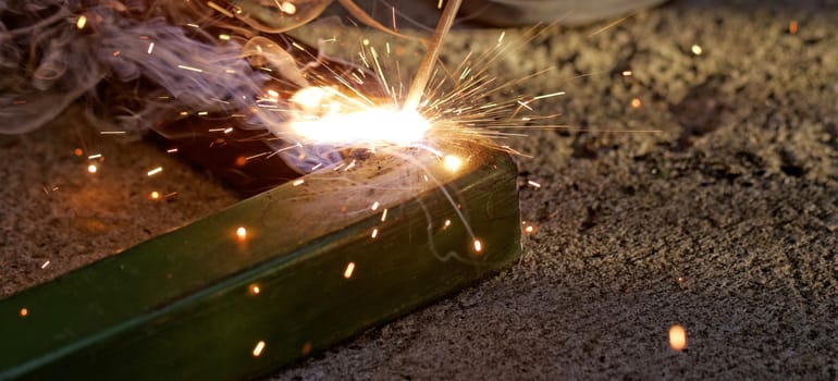 Iron welding with bright light and smoke at manufacturing