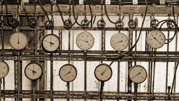 industrial steam pipes in a electricity power plant with pressure meter sephia