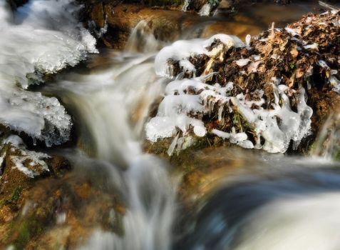 Small beautiful water cascade formed by melting snow