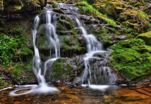 Beautiful waterfall falling over rocks in a small lake