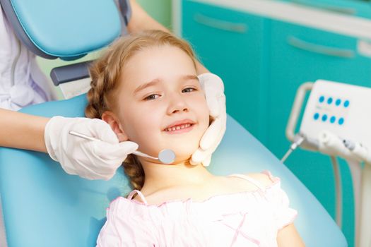 Little girl sitting in the dentists office