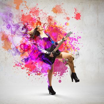 Young attractive rock girl playing the electric guitar