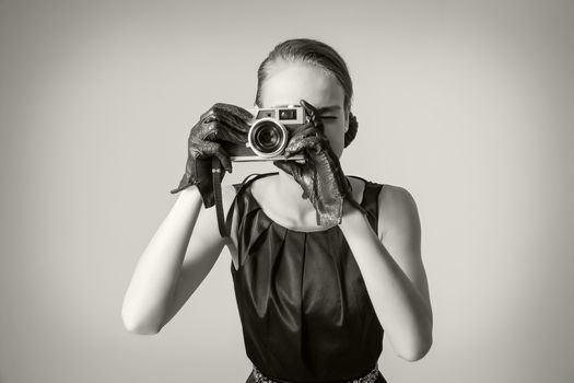 Fashion portrait of beautiful young girl in classic vintage style with an analogue photo camera