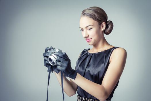 Fashion portrait of beautiful young girl in classic vintage style with an analogue photo camera