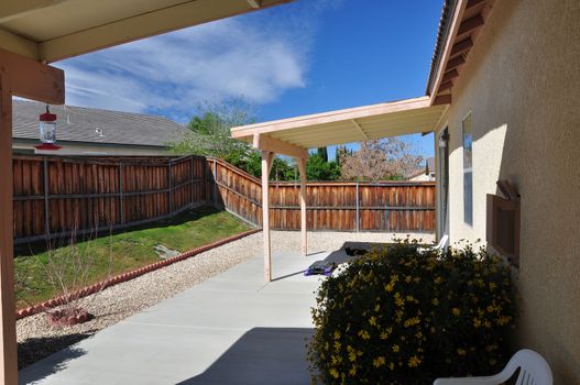 View of a backyard covered patio at a tract house in southern California.